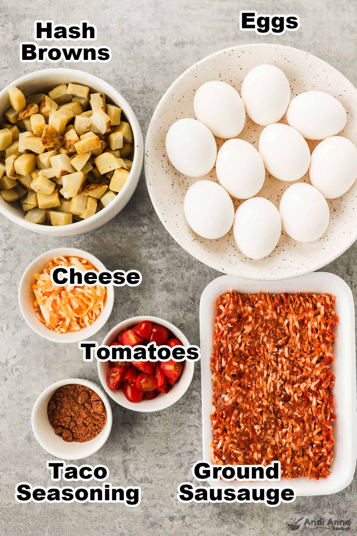 Recipe ingredients in bowls including  hash browns, eggs, shredded cheese, sliced tomatoes, ground sausage, and taco seasoning.