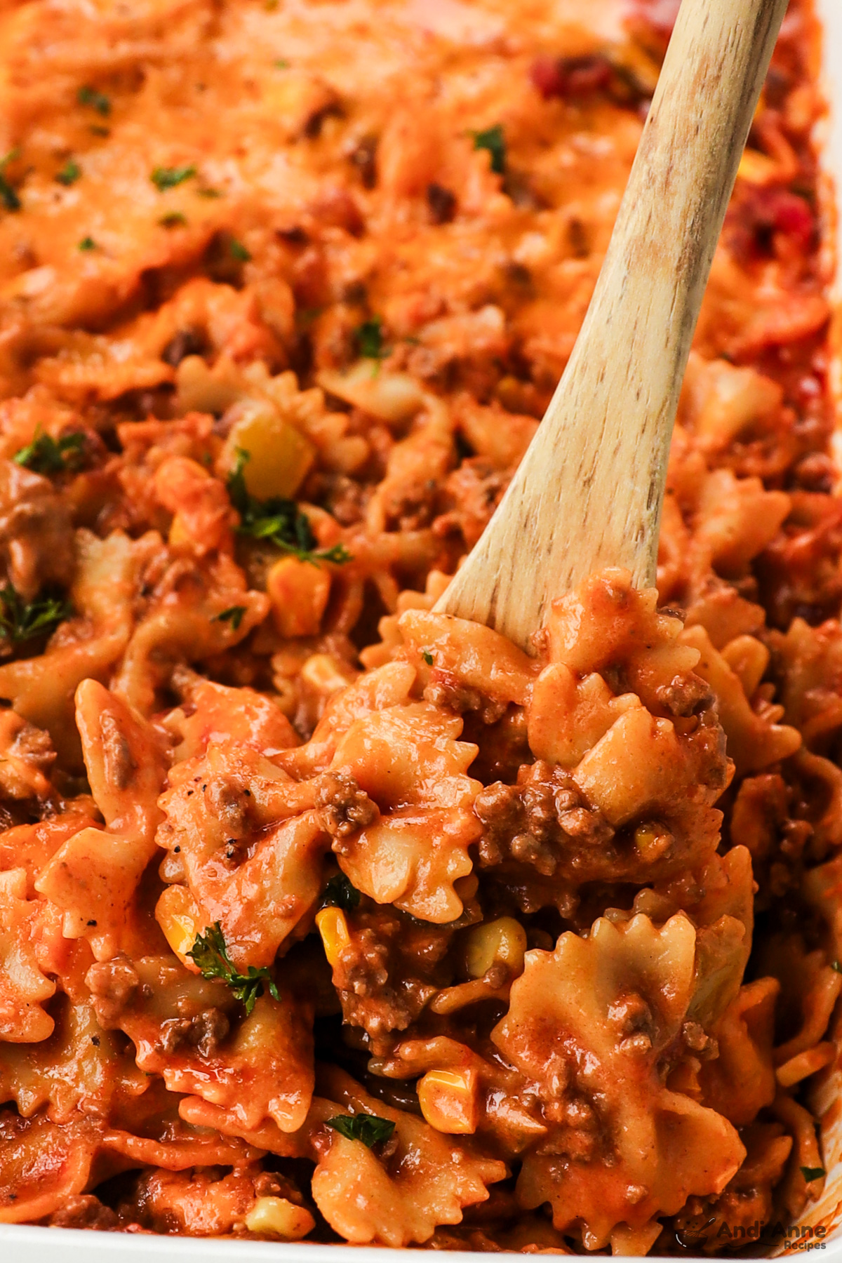 Close up of a wood spoon scooping the sloppy joe casserole.