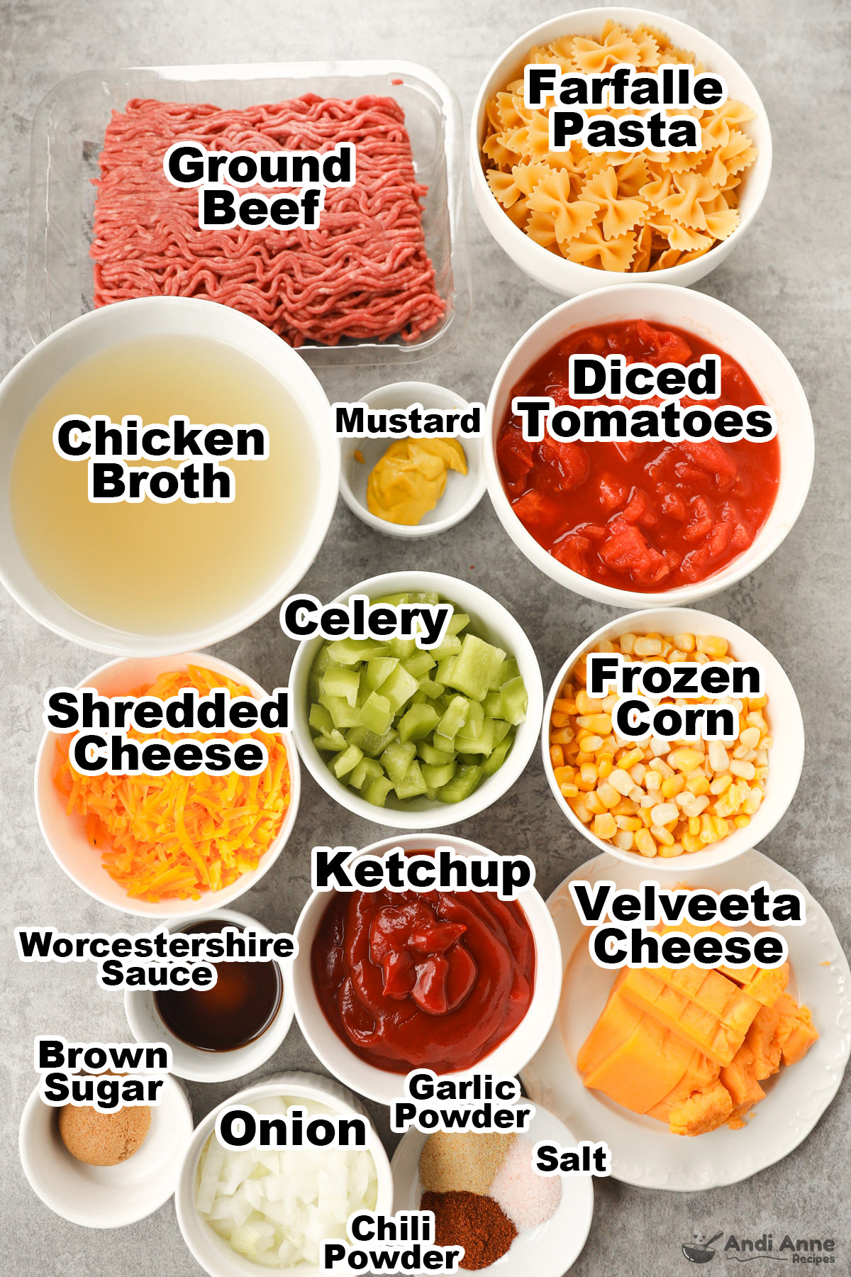 Recipe ingredients in bowls including pasta, raw ground beef, broth, diced tomatoes, mustard, chopped celery, shredded cheese, frozen corn, ketchup, cheese, and spices.