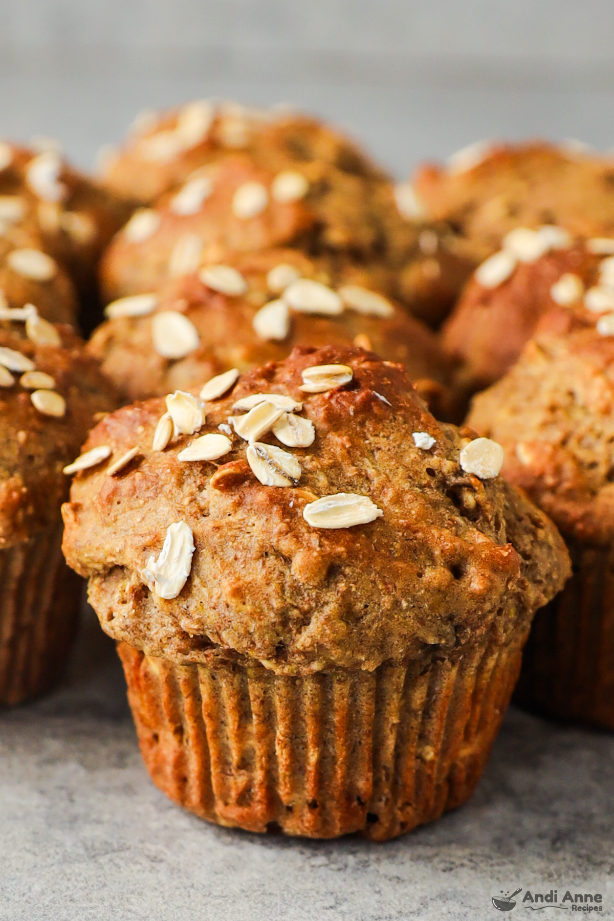 Close up of whole wheat banana muffin topped with a sprinkle of rolled oats