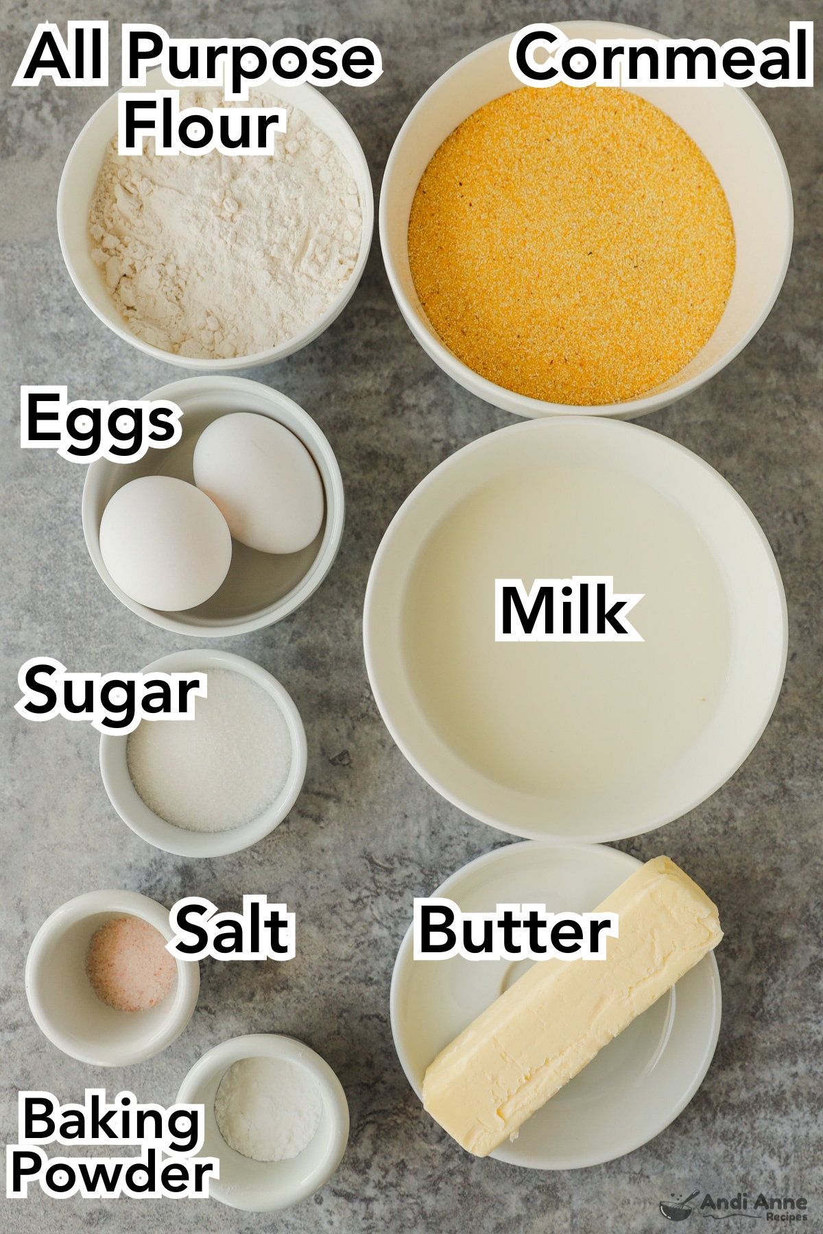 Ingredients in bowls including flour, cornmeal, eggs, milk, sugar, salt and butter