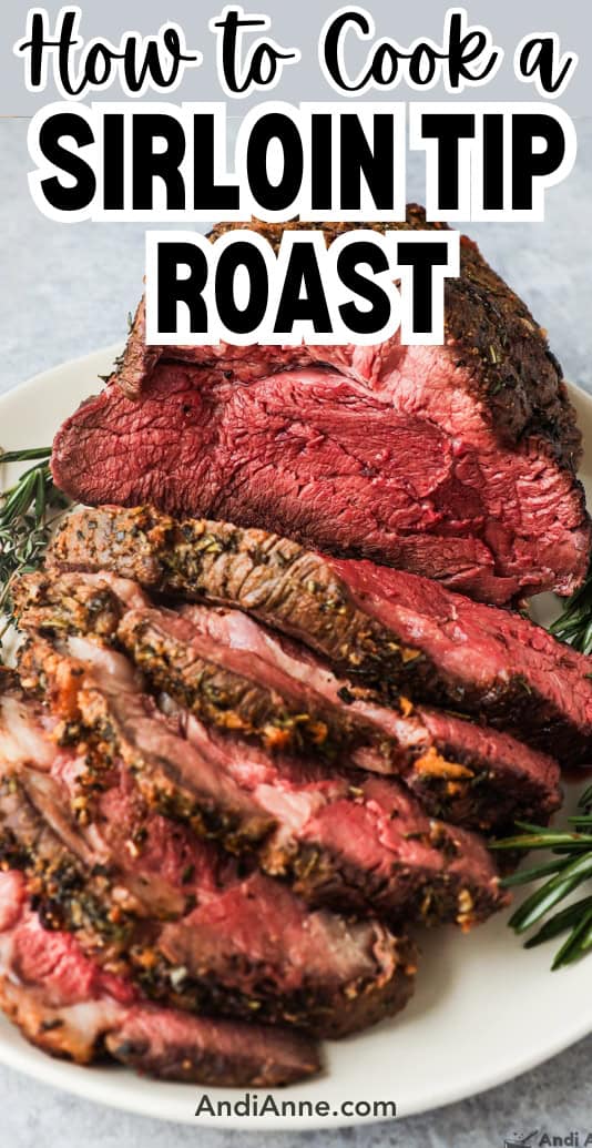 A sirloin tip roast sliced and on a plate with some fresh rosemary