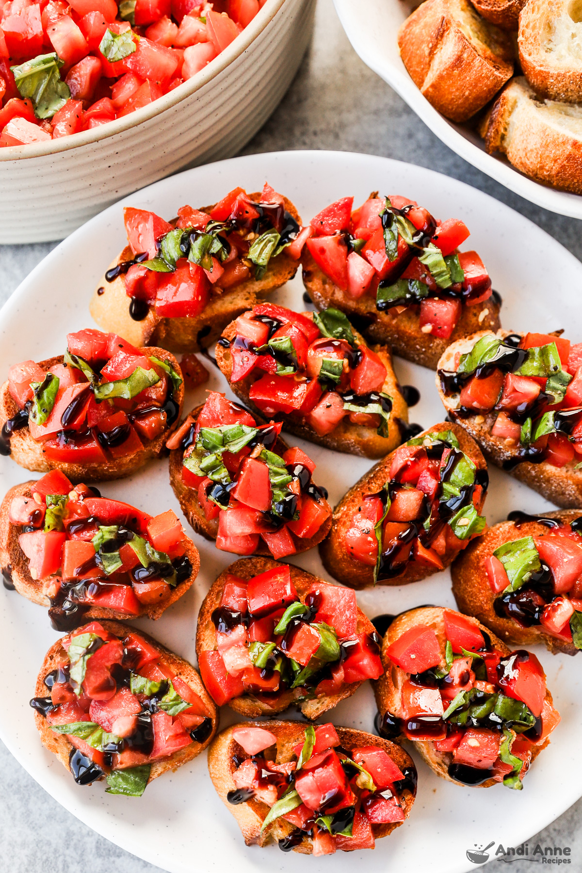 Close up of a plate of bruschetta baguett slices drizzled with balsamic glaze