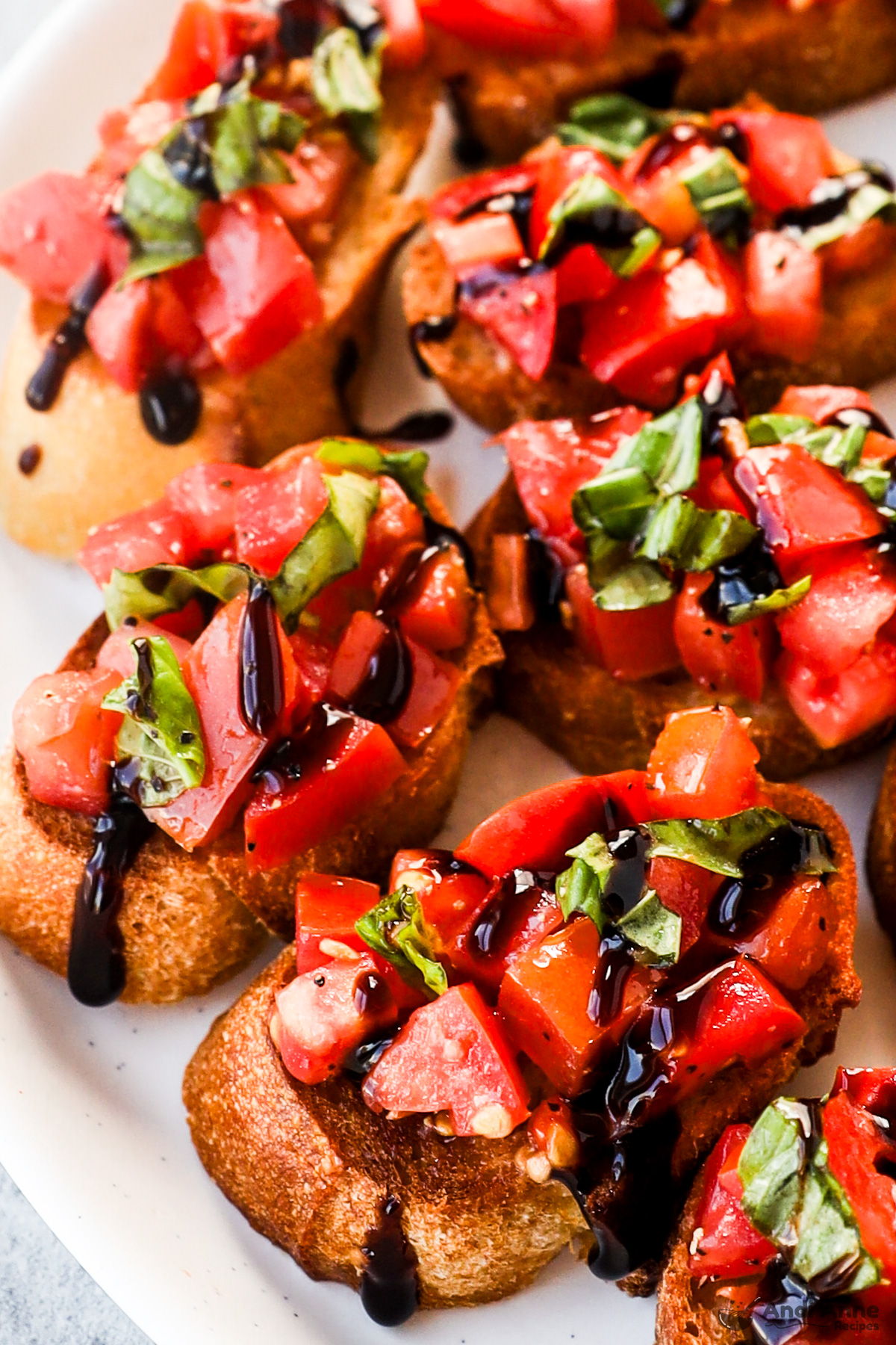 Close up of fresh homemade bruschetta on toasted baguette slices and drizzled with balsamic