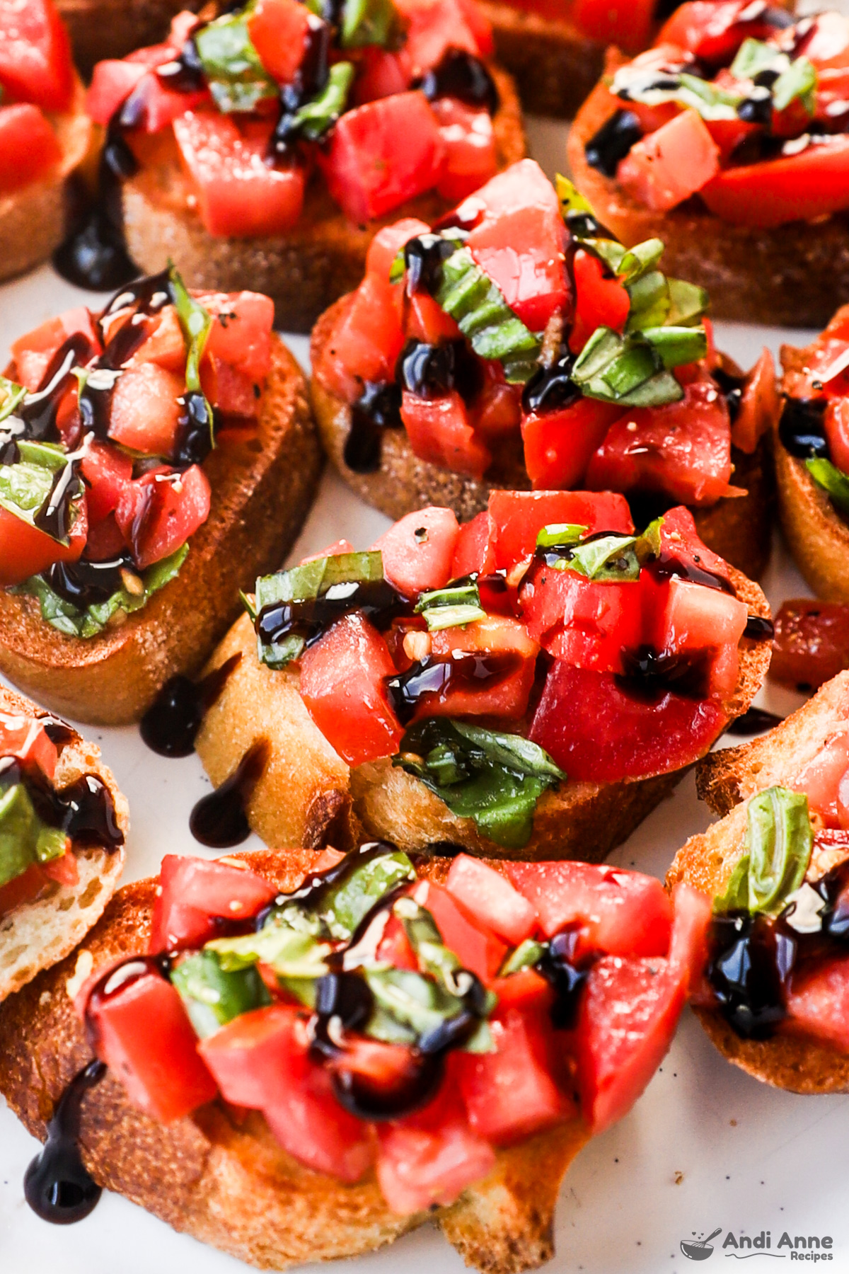 Close up of bruschetta on baguetta slices drizzled with balsamic glaze