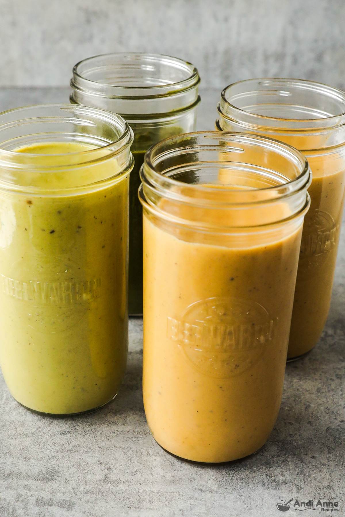 Four mason jars with different pureed creamy soups inside