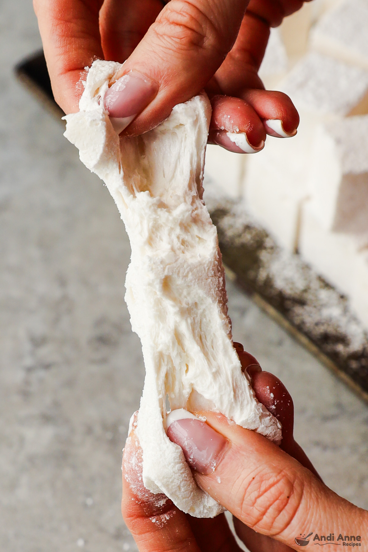 Hands stretching a marshmallow