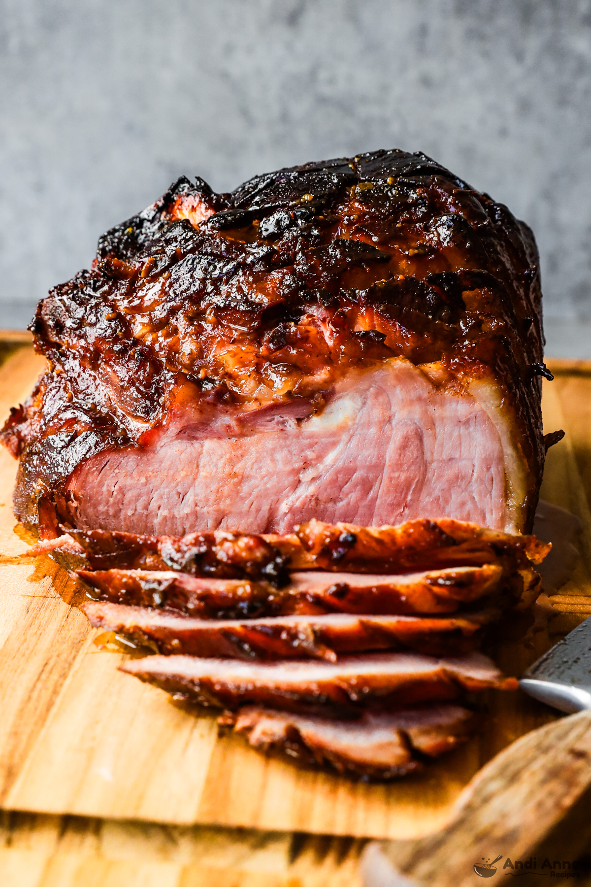 A cooked glazed ham on a cutting board