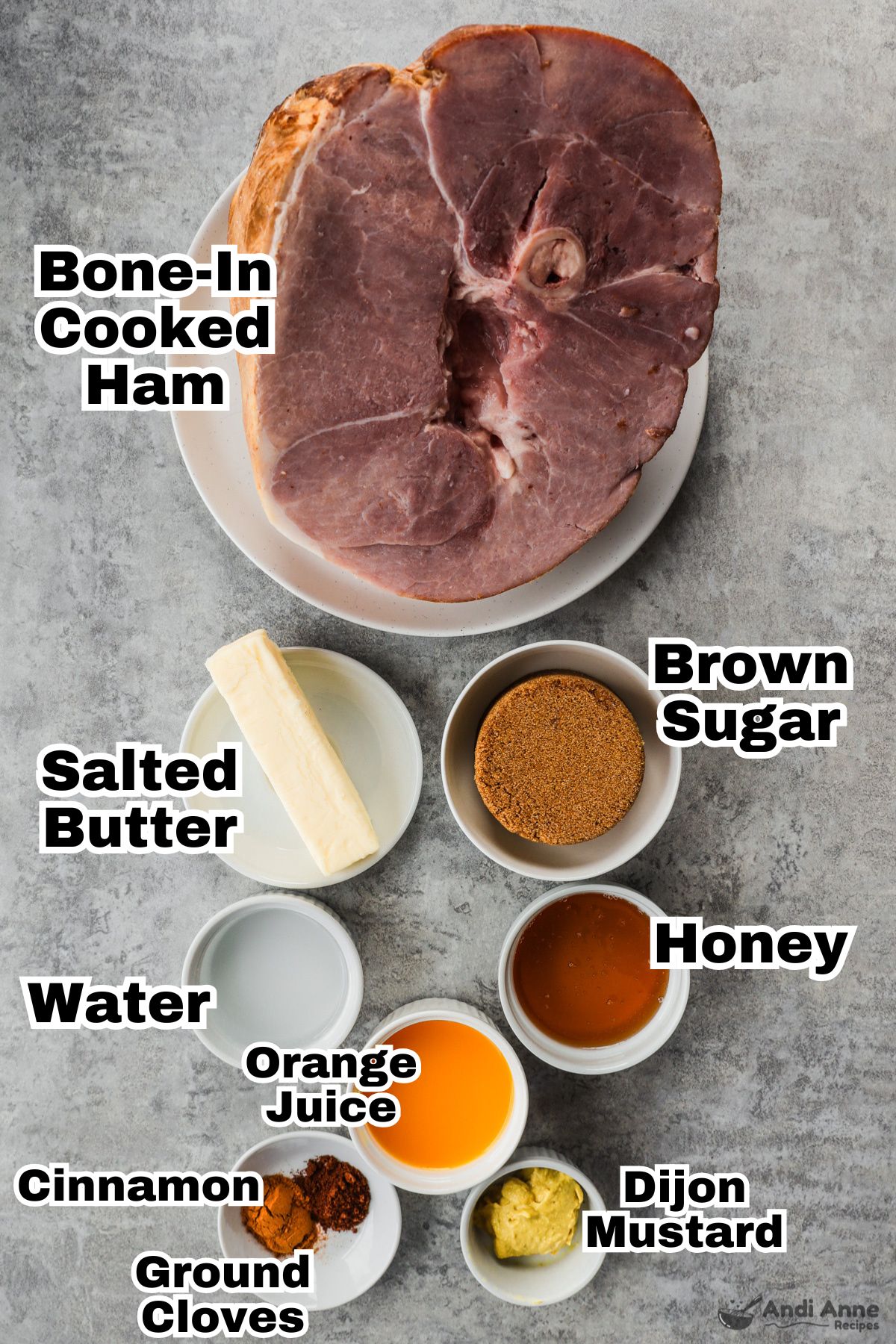 Recipe ingredients in bowls including brown sugar, stick of butter, honey, orange juice, cinnamon, ground cloves, dijon mustard and a bone in cooked ham 