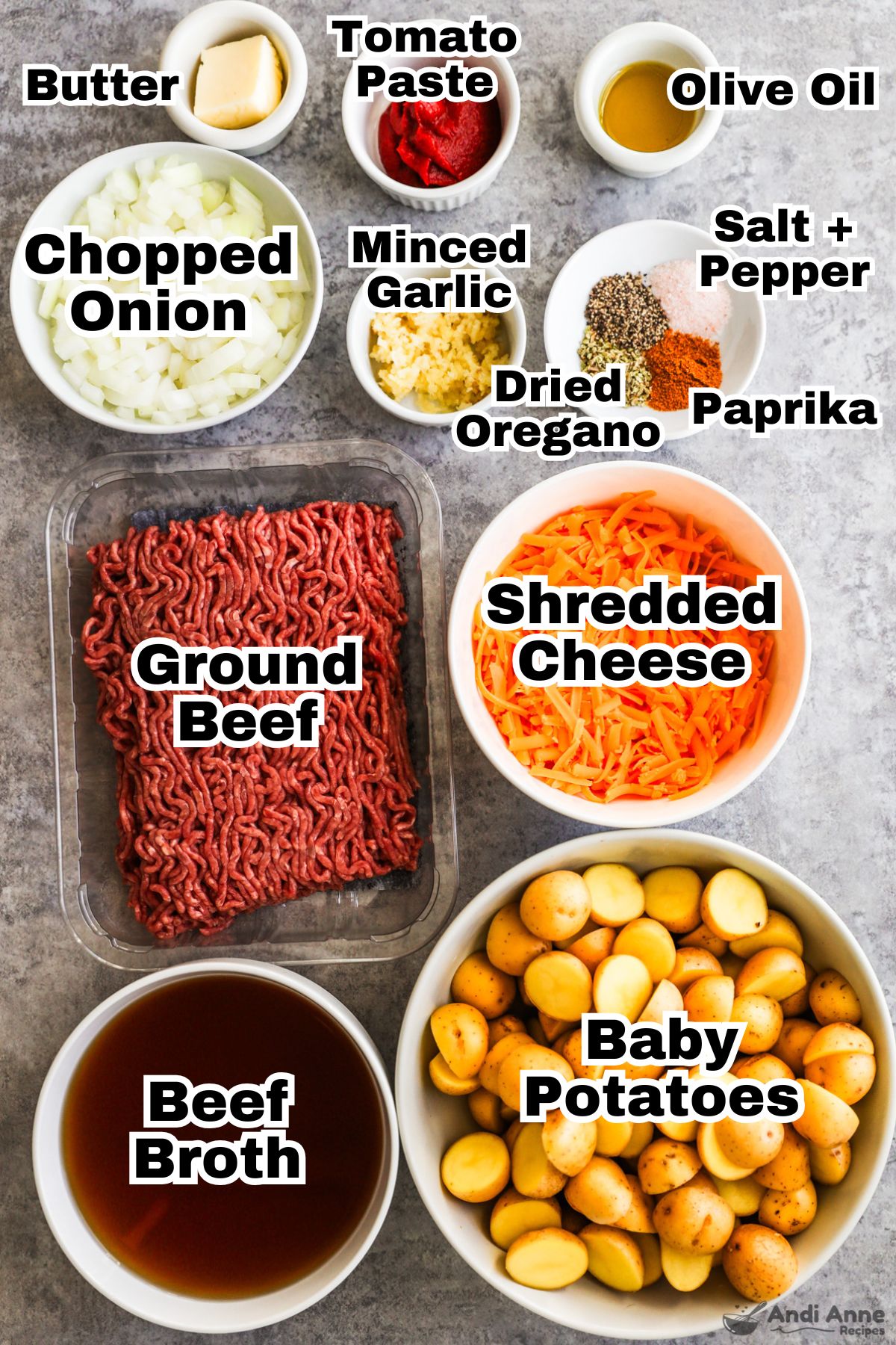 Recipe ingredients in bowls including chopped onion, olive oil, spices, minced garlic, shredded cheese, ground beef, baby potatoes, and beef broth