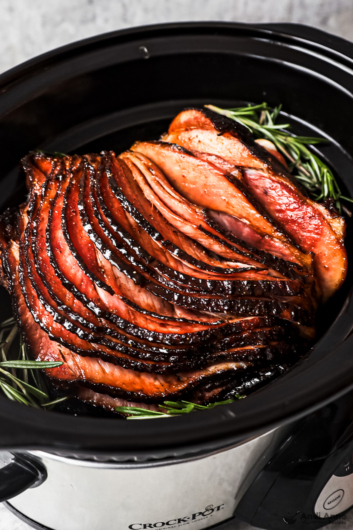 A slow cooker with a big sliced ham