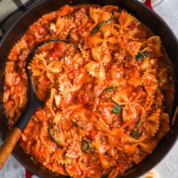 Pot of lasagna soup with bow tie pasta and a soup ladle