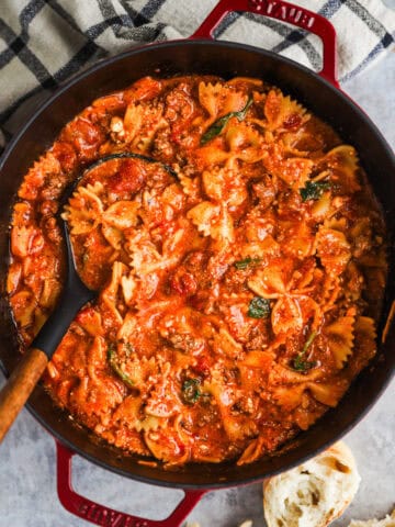 Pot of lasagna soup with bow tie pasta and a soup ladle