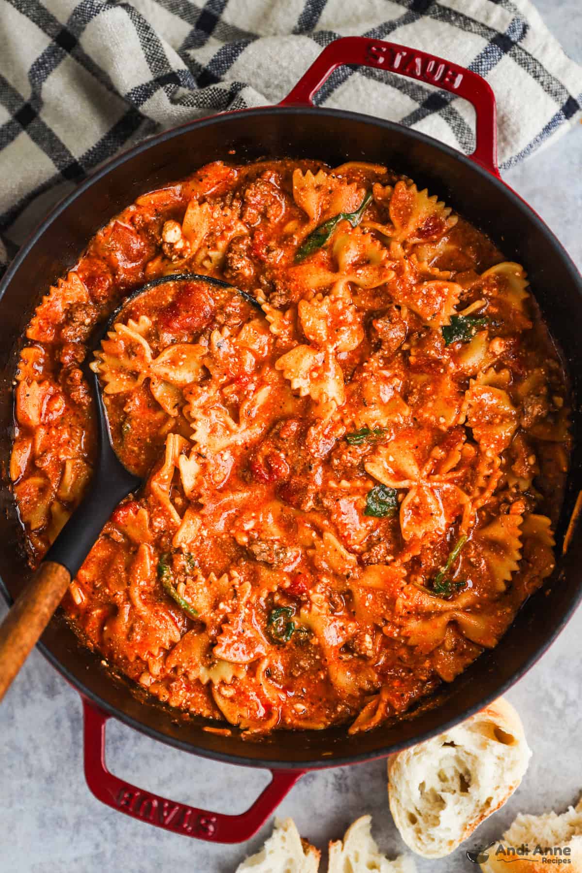 Pot of lasagna soup with bow tie pasta and a soup ladle