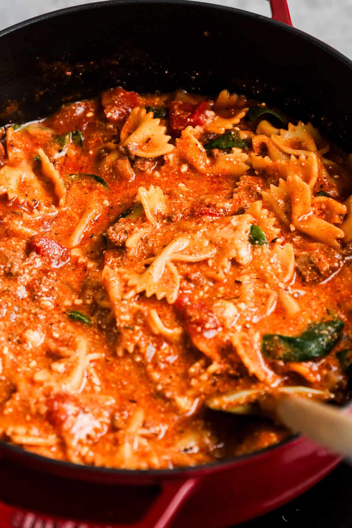 A pot of lasagna soup with bowtie pasta and creamy red sauce