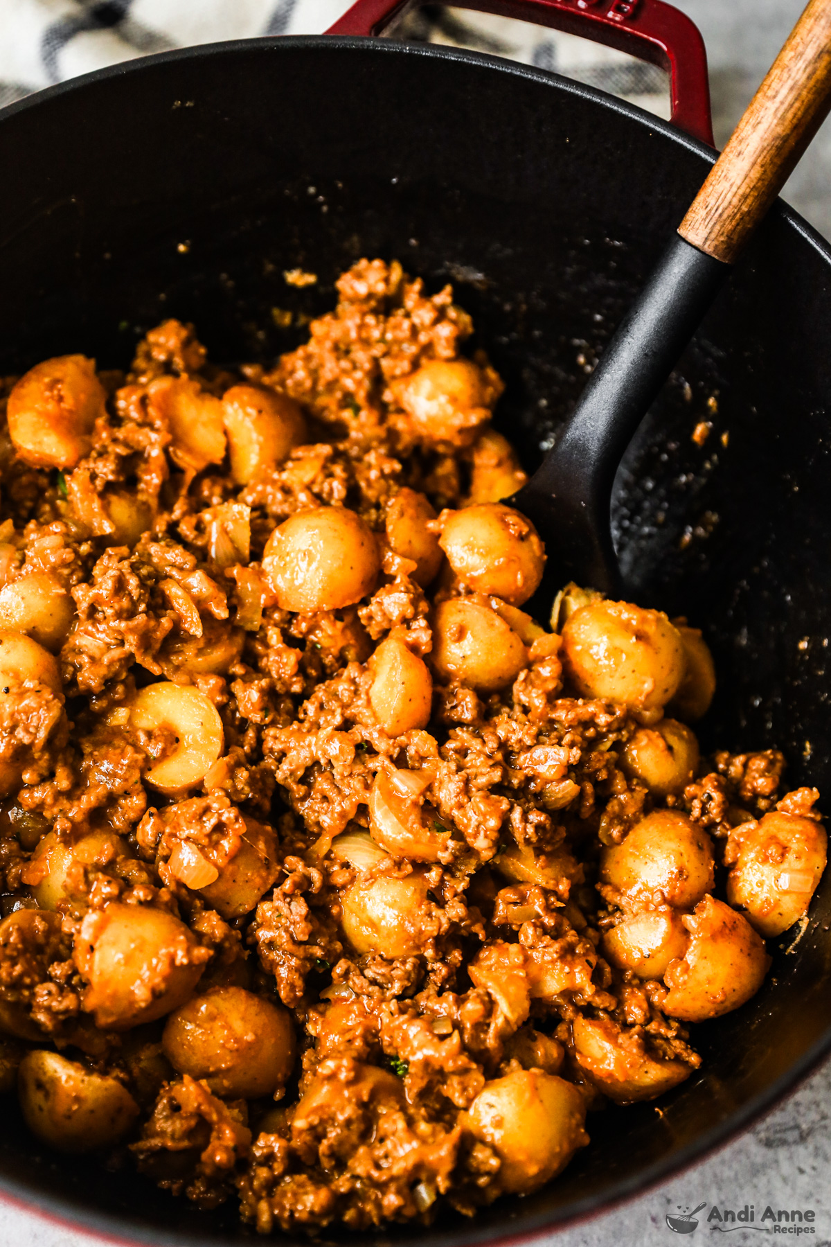 Close up of cheesy ground beef potatoes with a soup ladle