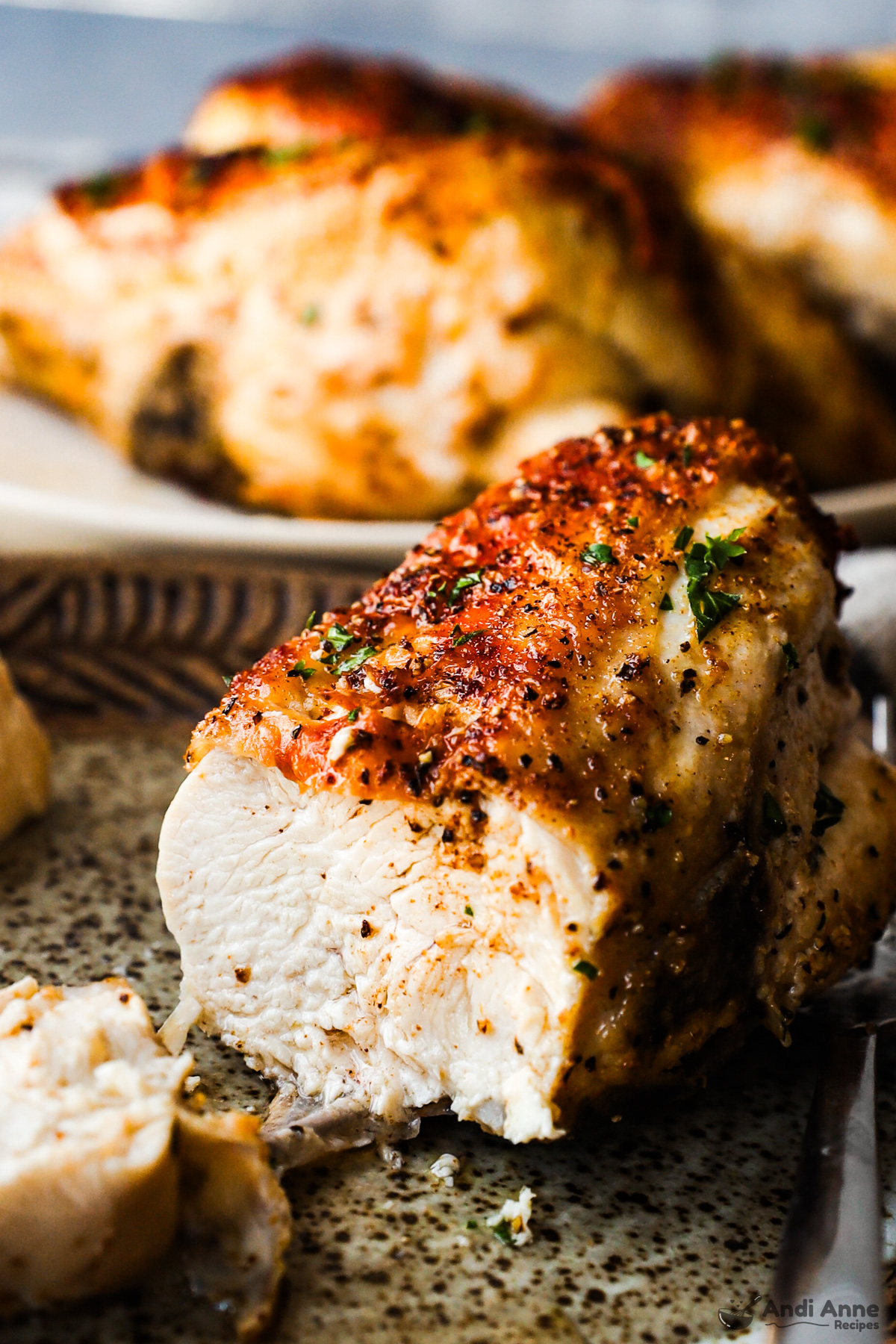 A chicken breast close up with a slice cut out of it