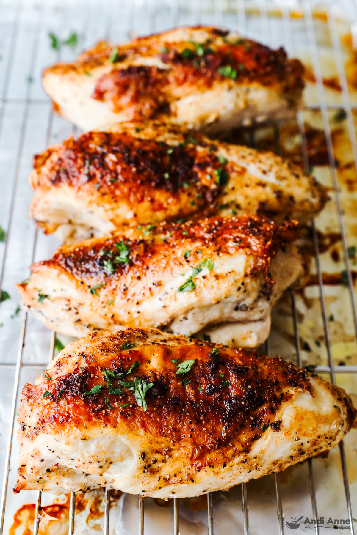 Close up of roasted bone-in skin on chicken breasts sitting on a rack