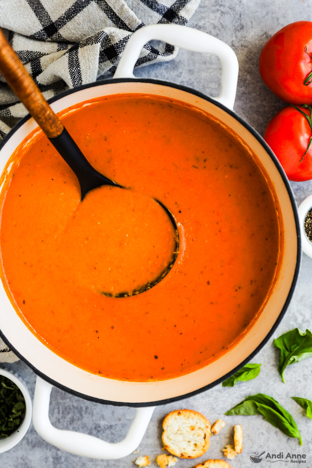 A pot of tomato soup with soup ladle