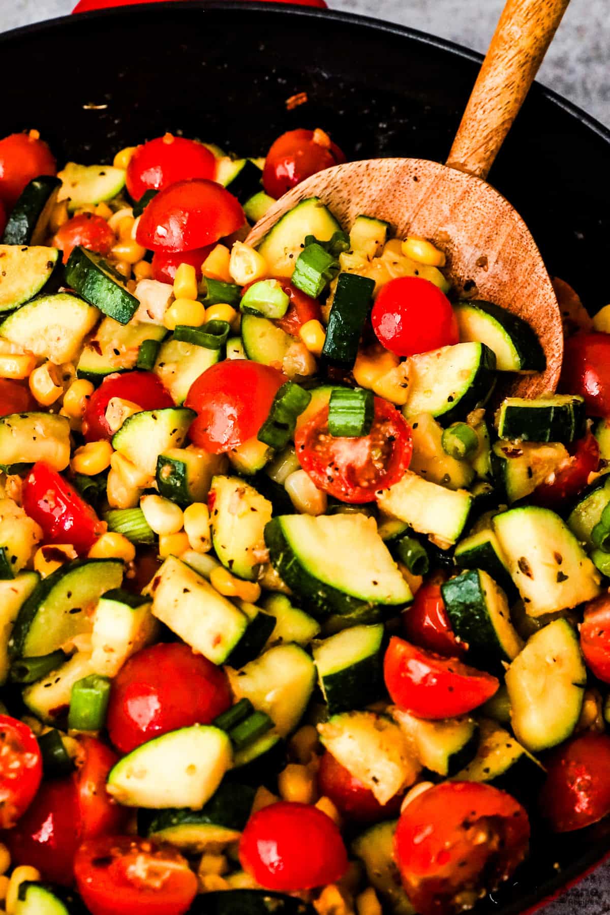 Closeup of chopped zucchini, tomatoes, corn and green onion