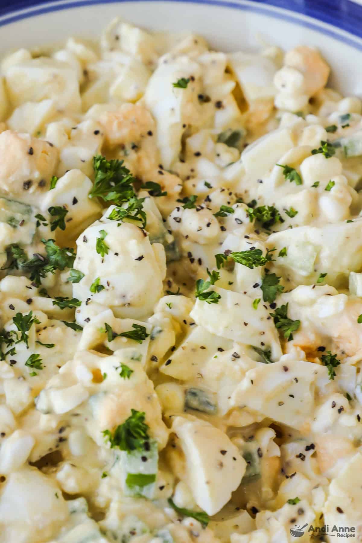 Closeup of finished egg salad with parsley as garnish. 
