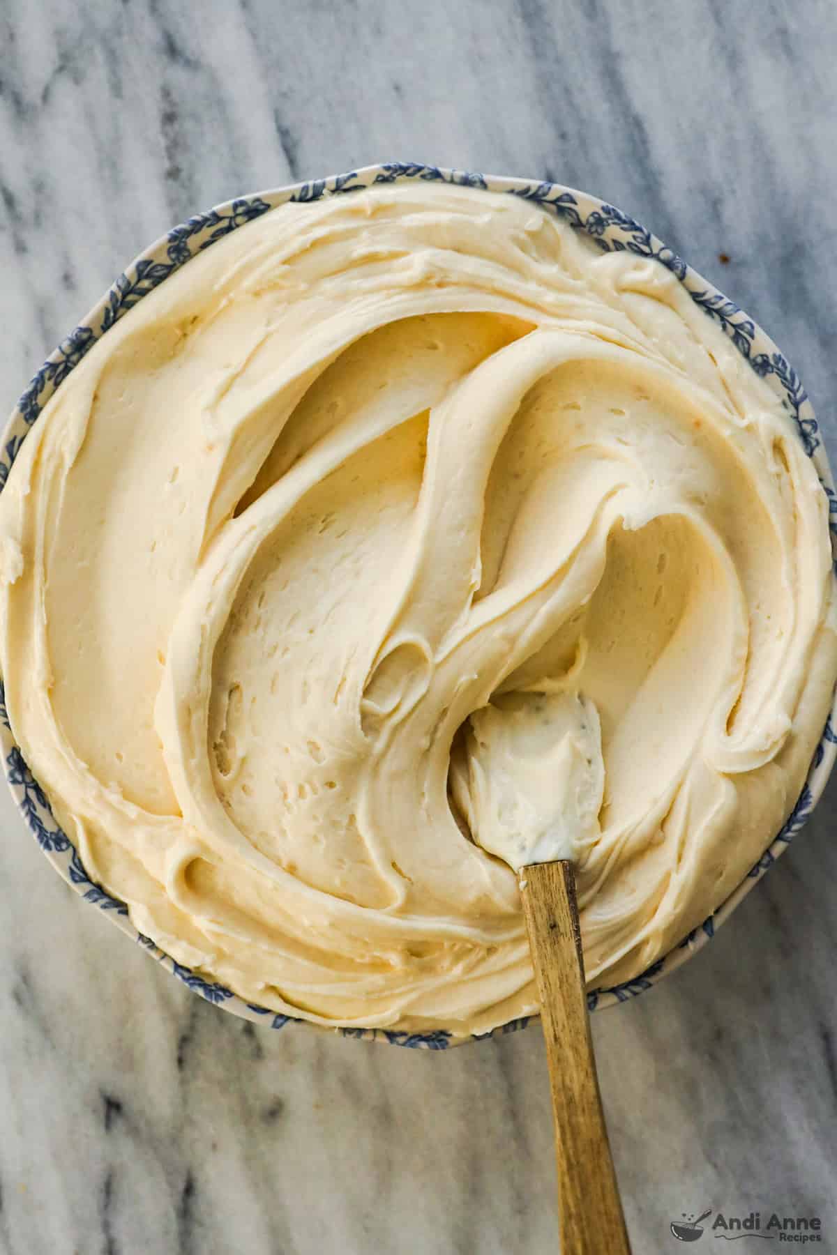 Cream cheese frosting in a bowl with a small spatula