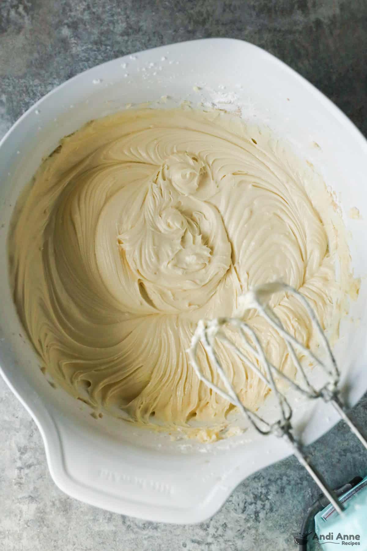Creamy Cream cheese frosting in a bowl with hand mixer