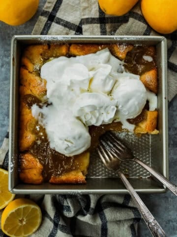 Magic Lemon Cobbler in the pan with a piece removed and two forks.