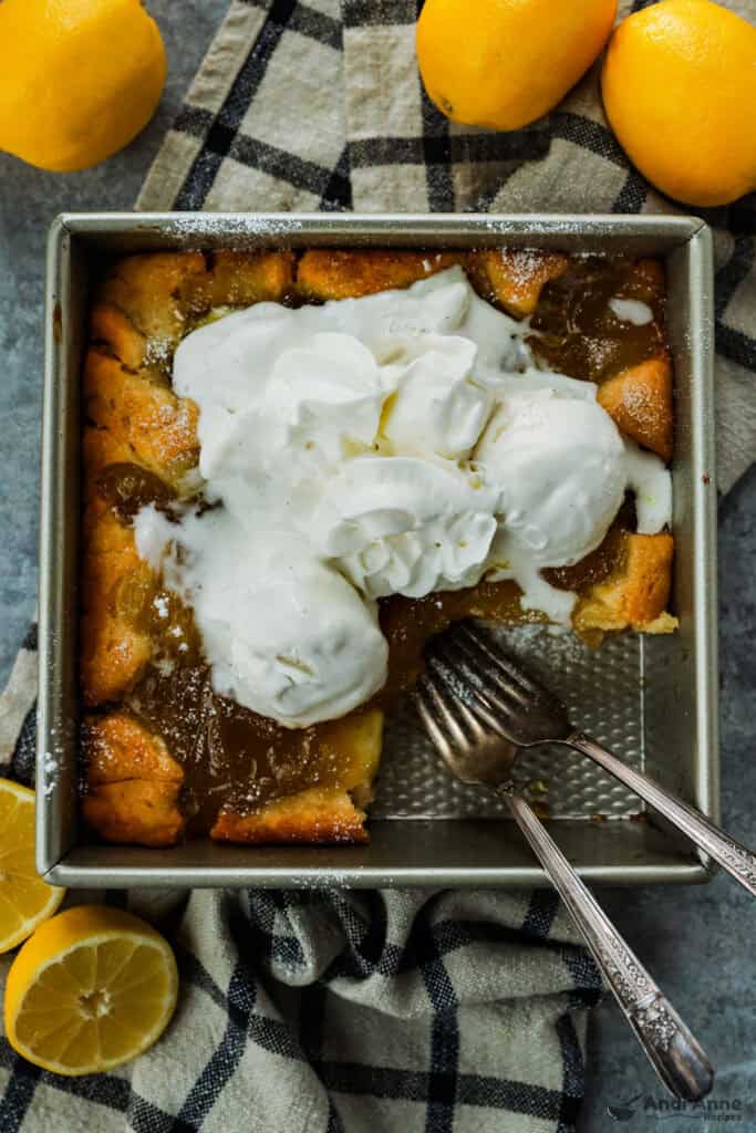 Magic Lemon Cobbler in the pan with a piece removed and two forks.