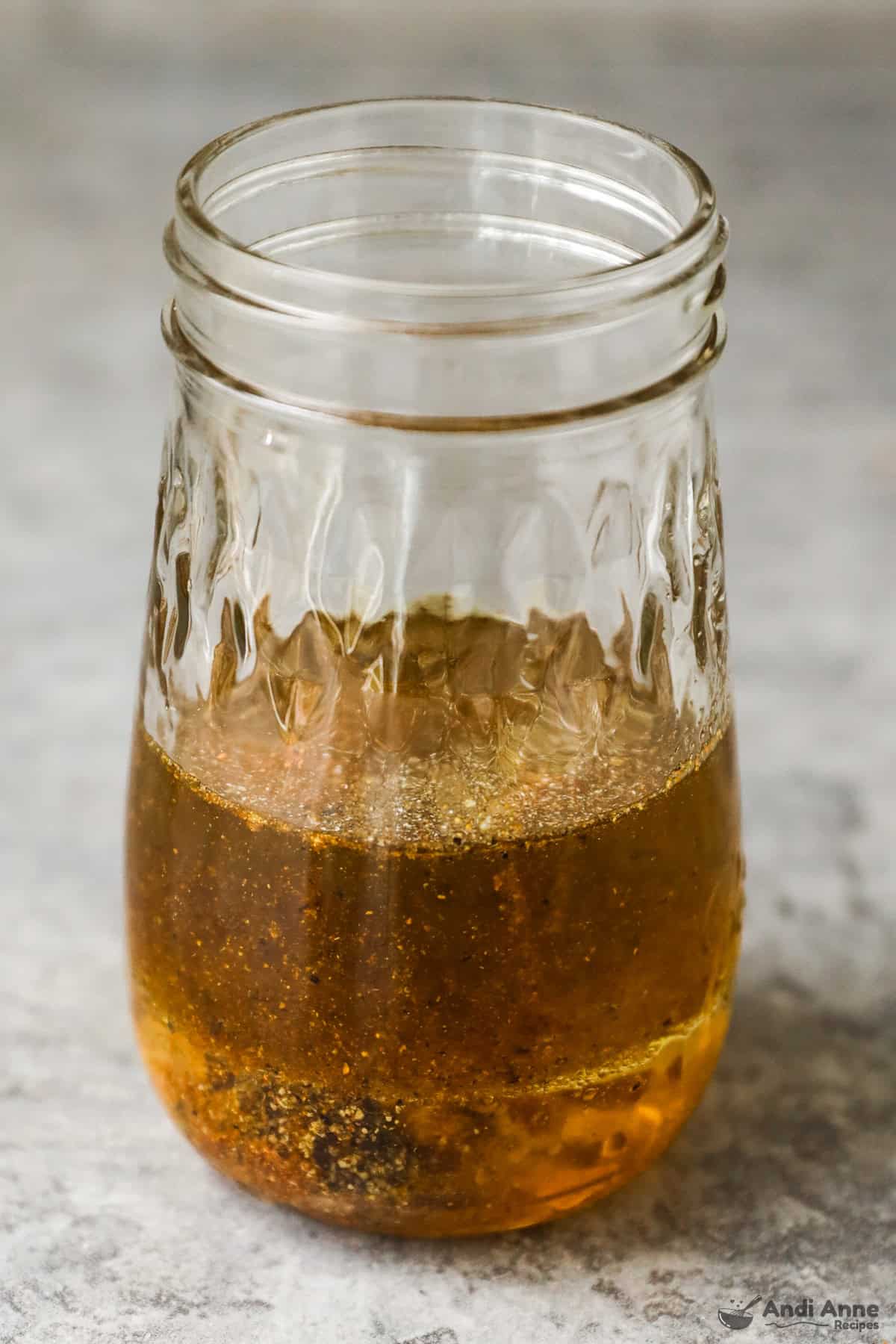 The ingredients for a classic vinaigrette dressing are in a mason jar.