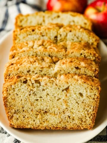 Slices of apple bread lined up on a plate.