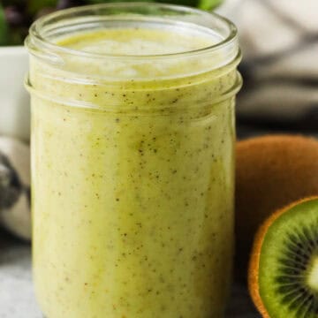 A mason jar full of kiwi citrus salad dressing.
