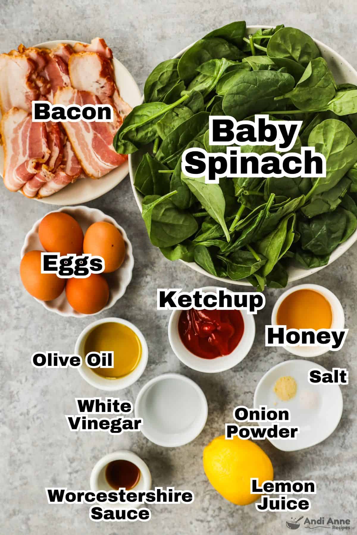 The ingredients to make classic spinach salad are in individual white bowls.