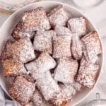 Beignets are dusted with powdered sugar.