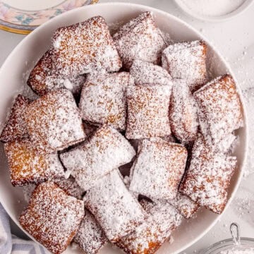 Beignets are dusted with powdered sugar.