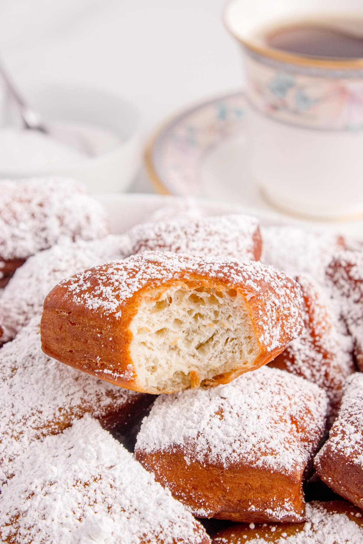 A stack of beignets with a bite taken out of one.