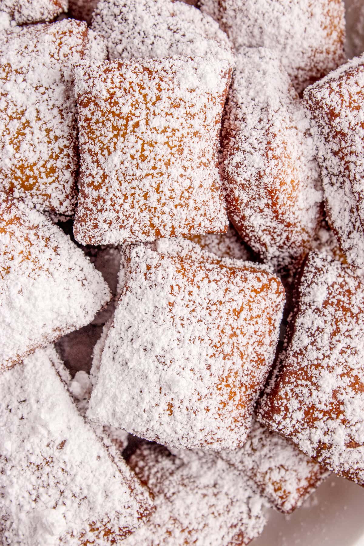 A close-up of powdered sugar-coated beignets.