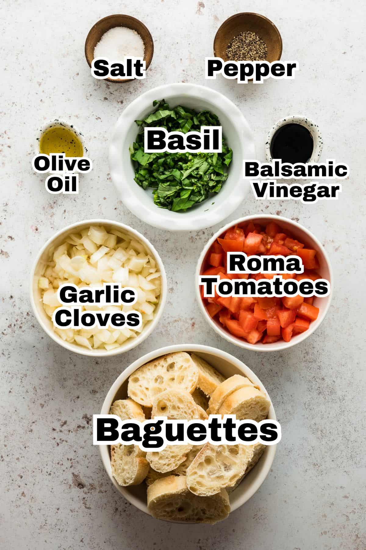 The ingredients to make tomato bruschetta are in small individual bowls.