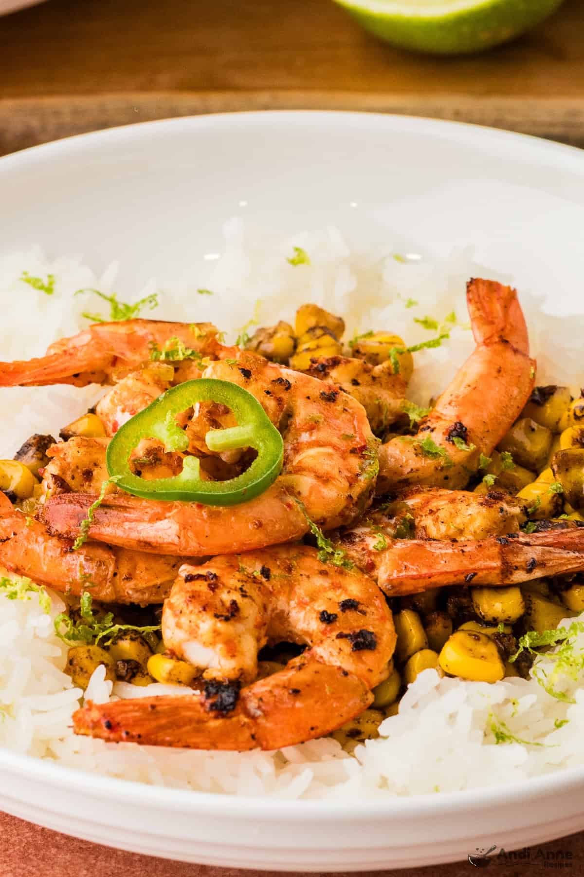 Chili lime shrimp and fire roasted corn served over a bed of rice and topped with a slice of jalapeño pepper.