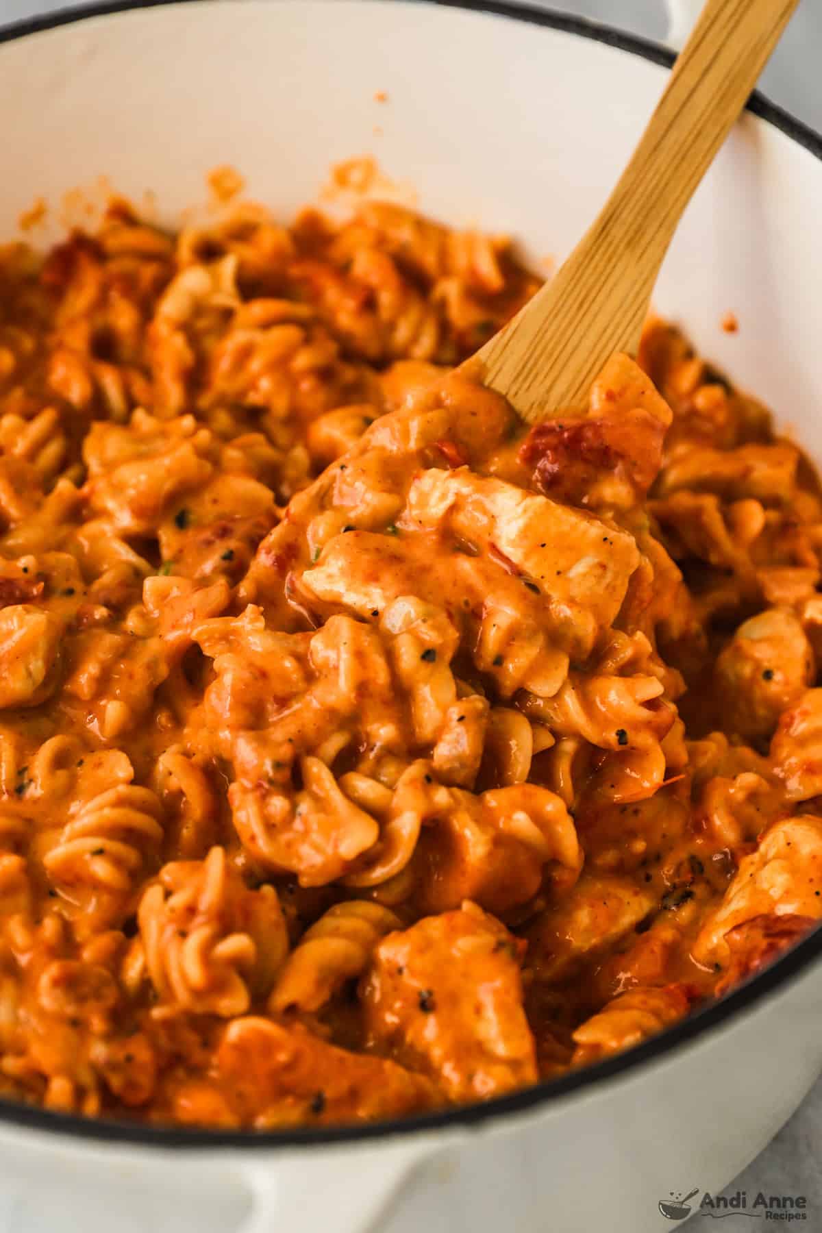 close up of barbecue chicken pasta with wood spoon