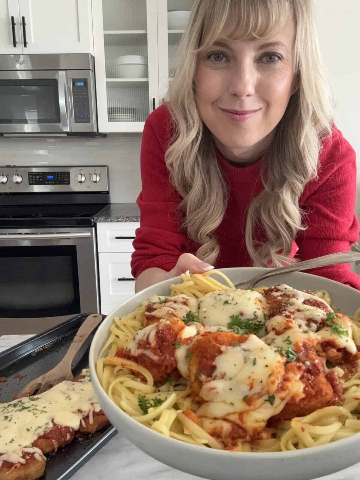 AndiAnne holding chicken nugget parmesan recipe on plate