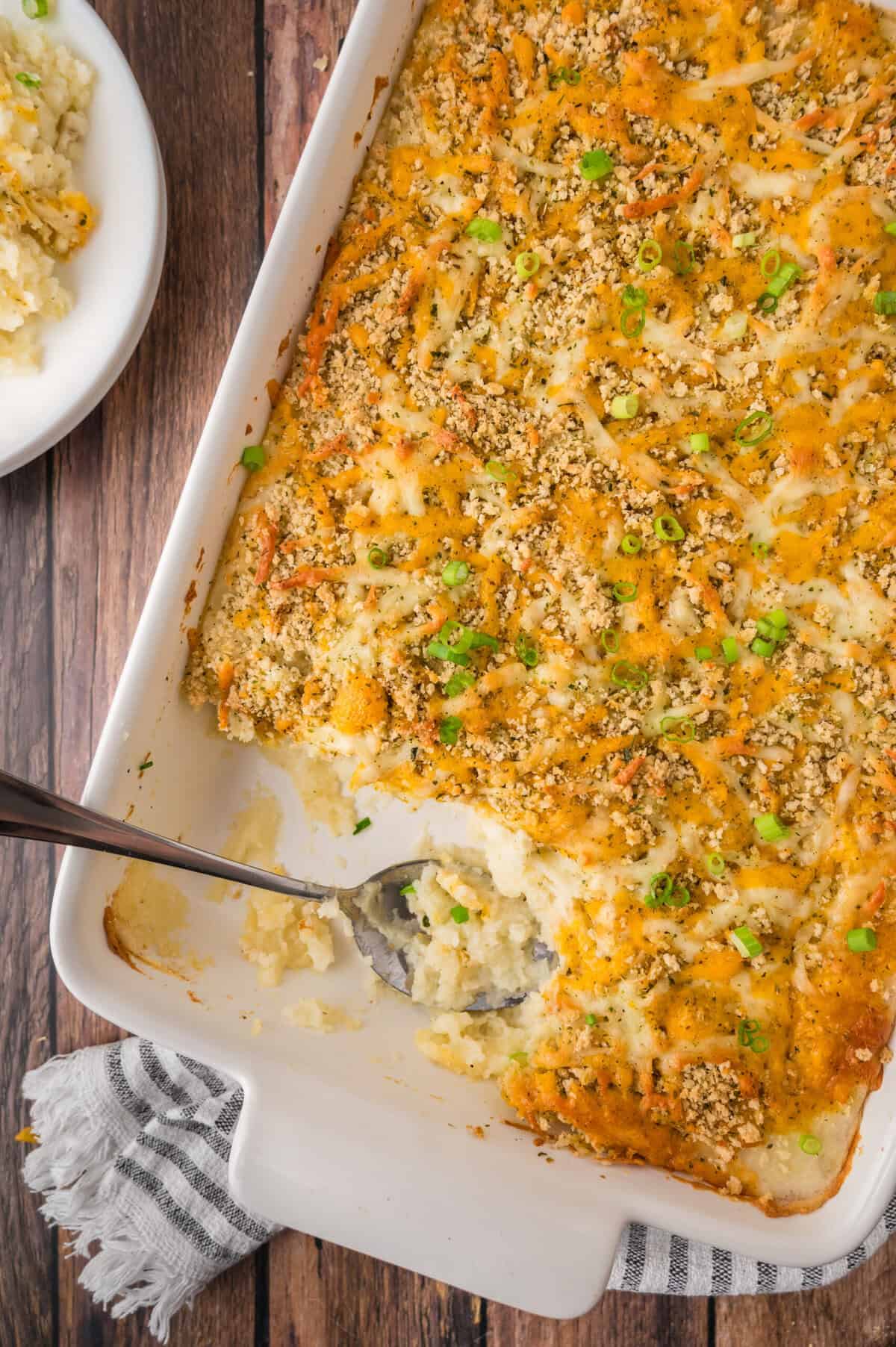 Cheesy mashed potato casserole in a large baking dish.