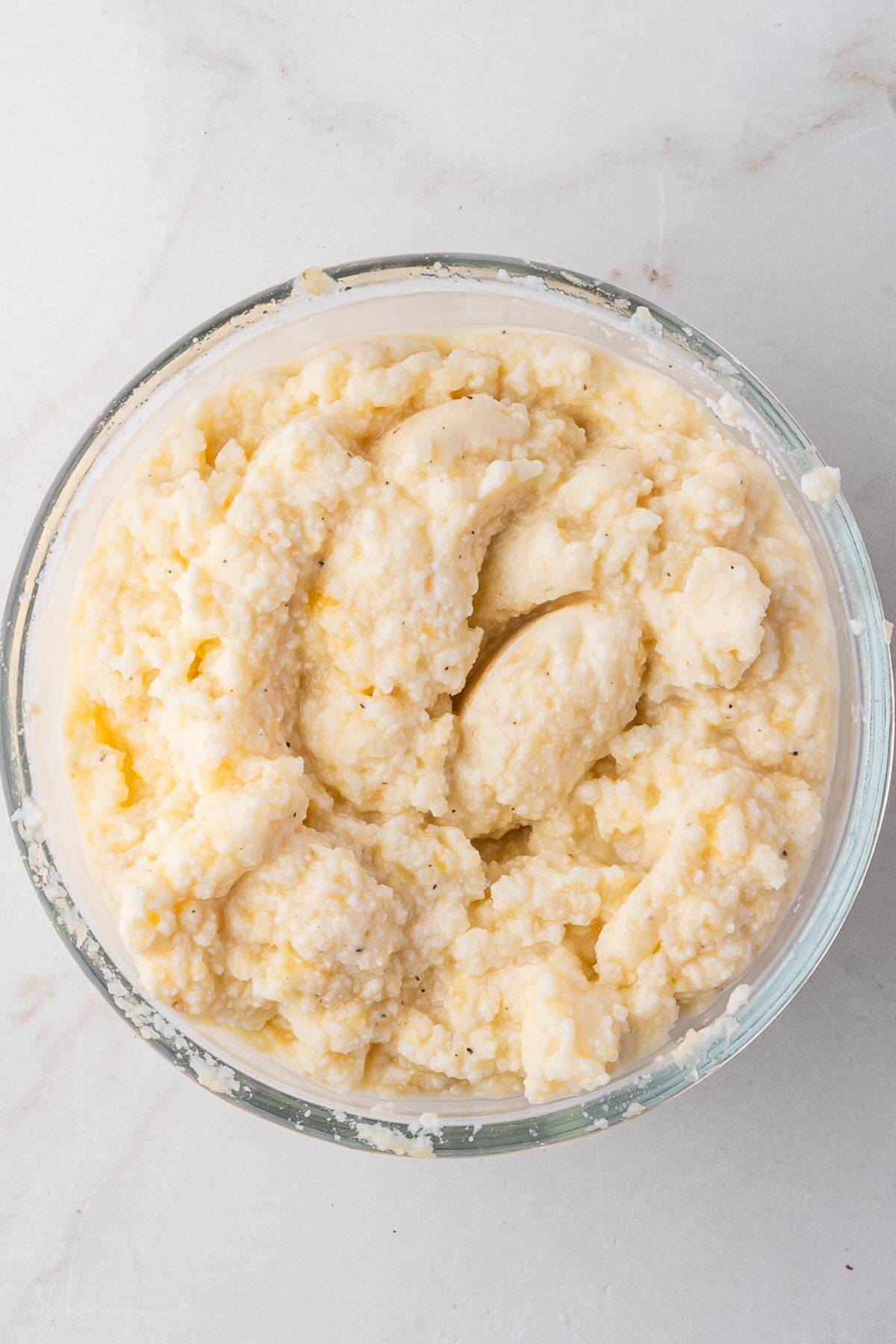 Ricotta, parmesan, egg, salt, and pepper are mixed together.