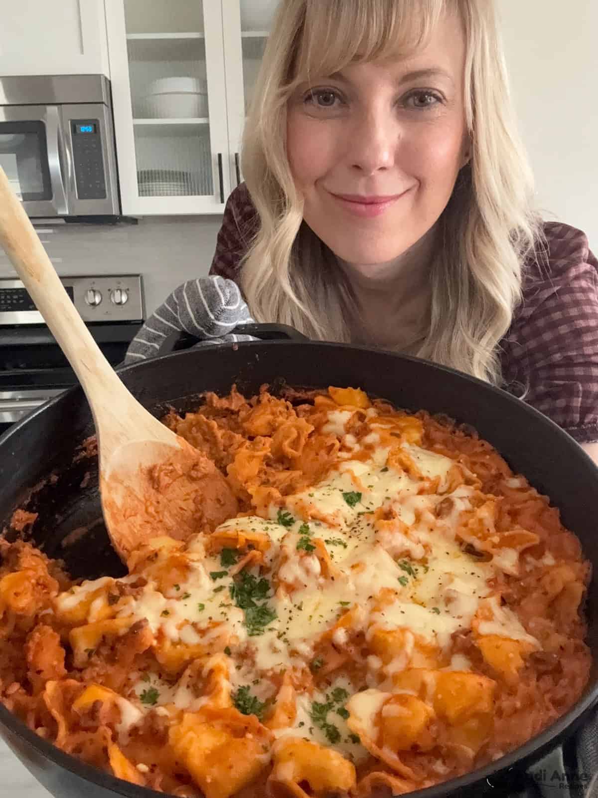 pic of andi holding skillet of baked tortellini casserole recipe