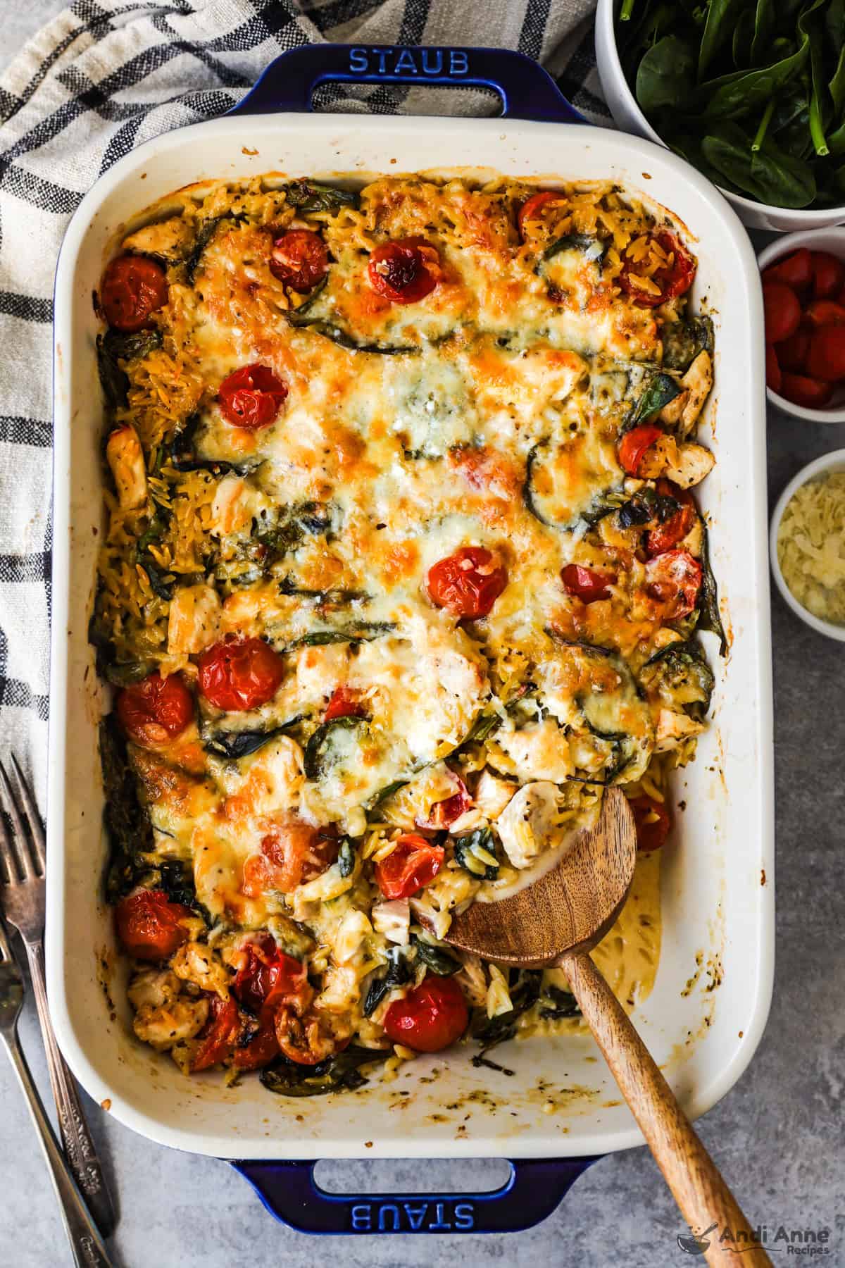 Baked greek chicken and orzo casserole in the pan with a serving removed.