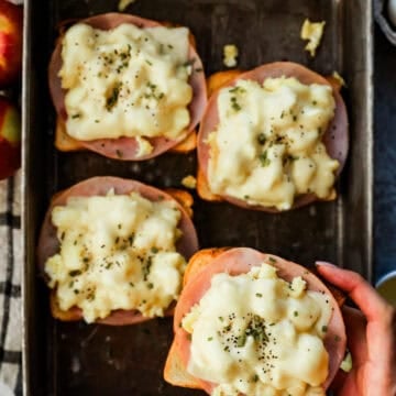 A tray of toast topped with ham, scrambled egg, and cheese.