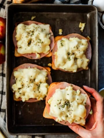 A tray of toast topped with ham, scrambled egg, and cheese.