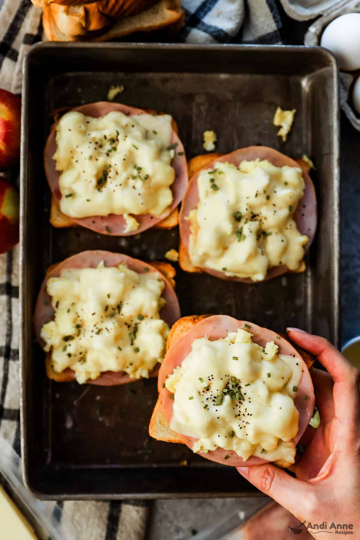 A tray of toast topped with ham, scrambled egg, and cheese.