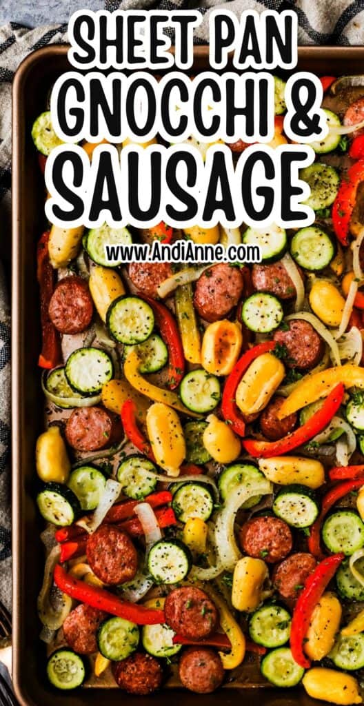 Sheet pan filled with roasted gnocchi, smoked sausage, and colorful veggies like peppers and zucchini.