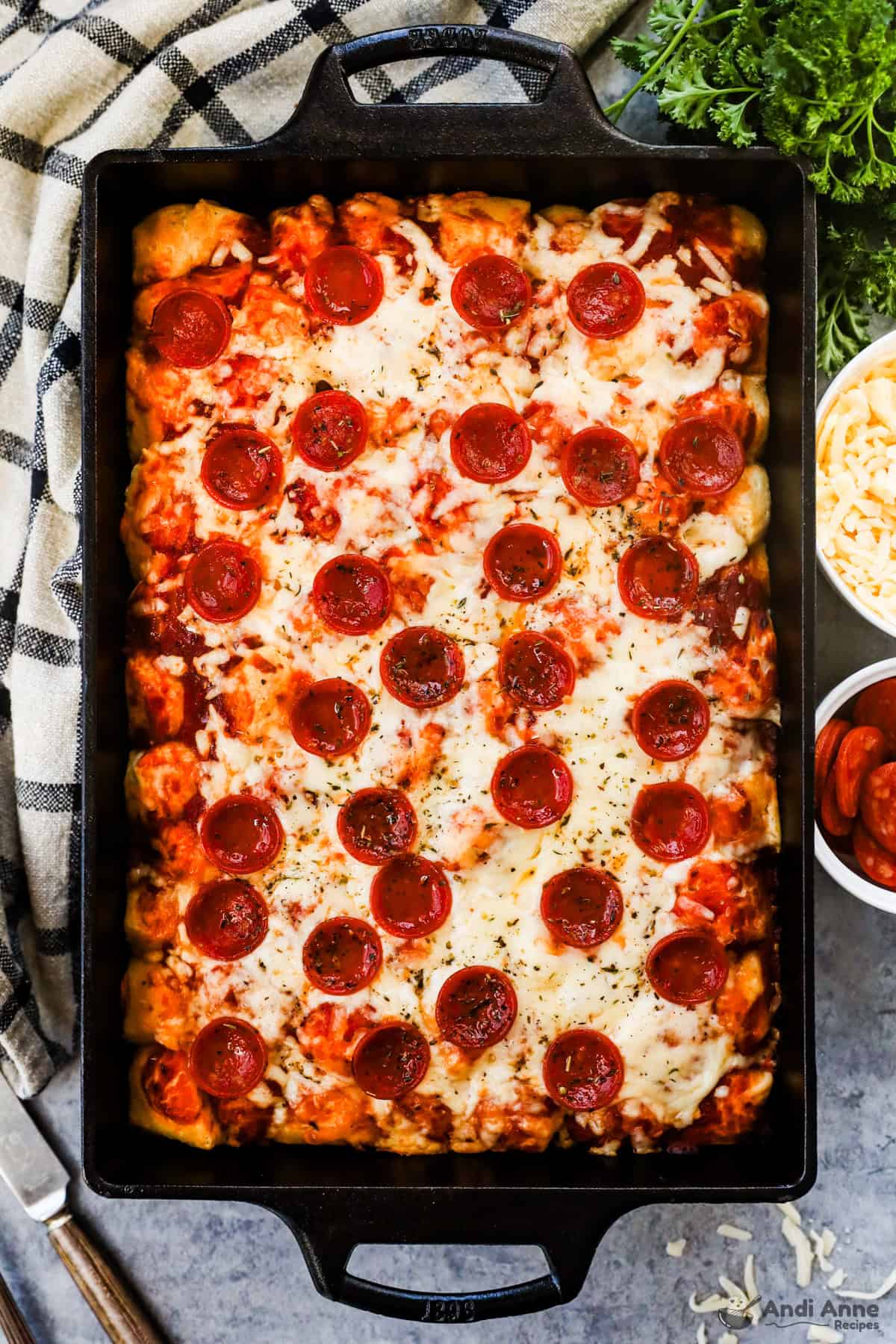 Baked pizza biscuit casserole in a 9x13 metal pan with golden cheese and pepperoni on top.